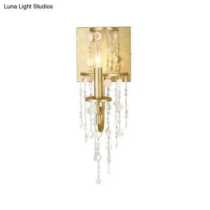 Vintage style gold wall sconce featuring a crystal beaded strand with cascading clear and frosted beads for bedroom lighting