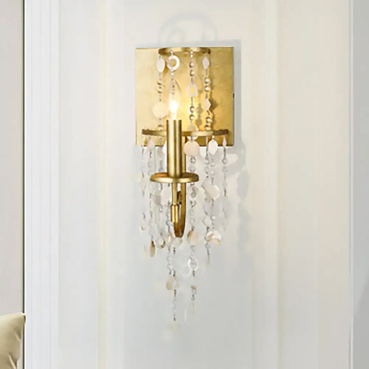Vintage style gold wall sconce with crystal beaded strand featuring clear and white cascading beads for bedroom lighting