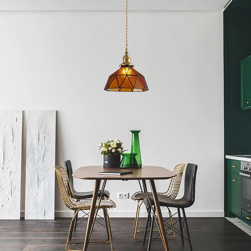 Vintage teal blue glass led pendant light with warm amber stained glass and brass frame hanging above dining table