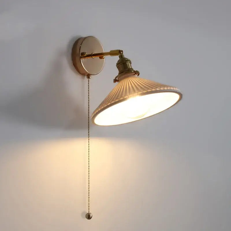 Brass-finished wall sconce with ribbed off-white ceramic shade and decorbites copper canopy led adjustable arm light