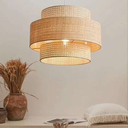 Beige woven rattan tiered wabi sabi pendant light with warm glowing interior ideal for dining room ambiance