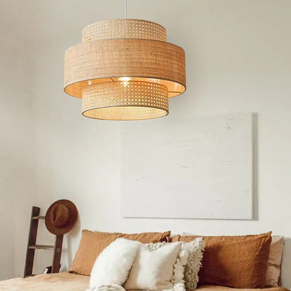Beige woven rattan wabi sabi pendant light with tiered cylindrical bamboo shade for dining room layered design