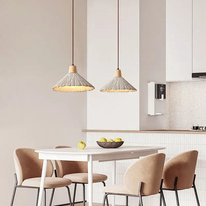 Two beige wabi sabi cement pendant lights with woven shades and wood tops hang above a dining table decorbites cement pendant