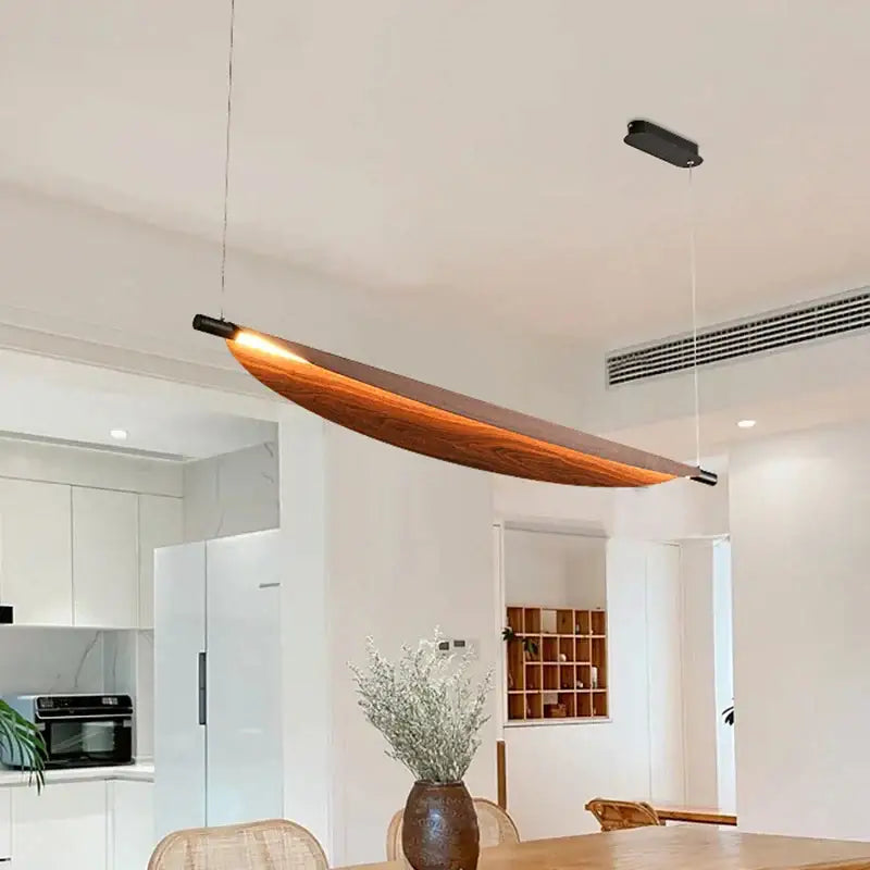 A sleek led wabi sabi wood pendant light with amber glow and black metal ends for dining room illumination