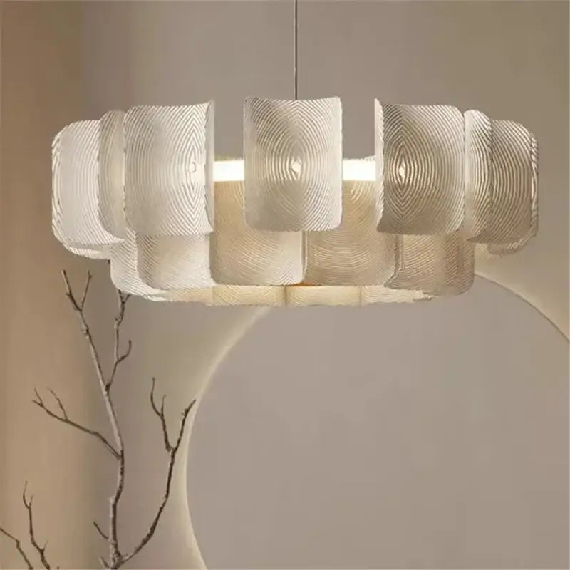 A modern off-white pendant light with layered ribbed segments and a painted iron finish for dining rooms