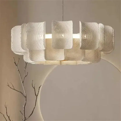 A modern off-white pendant light with layered ribbed segments and a painted iron finish for dining rooms