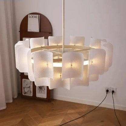 A modern off-white pendant light with a circular frame and wave-shaped glass panels in painted iron finish