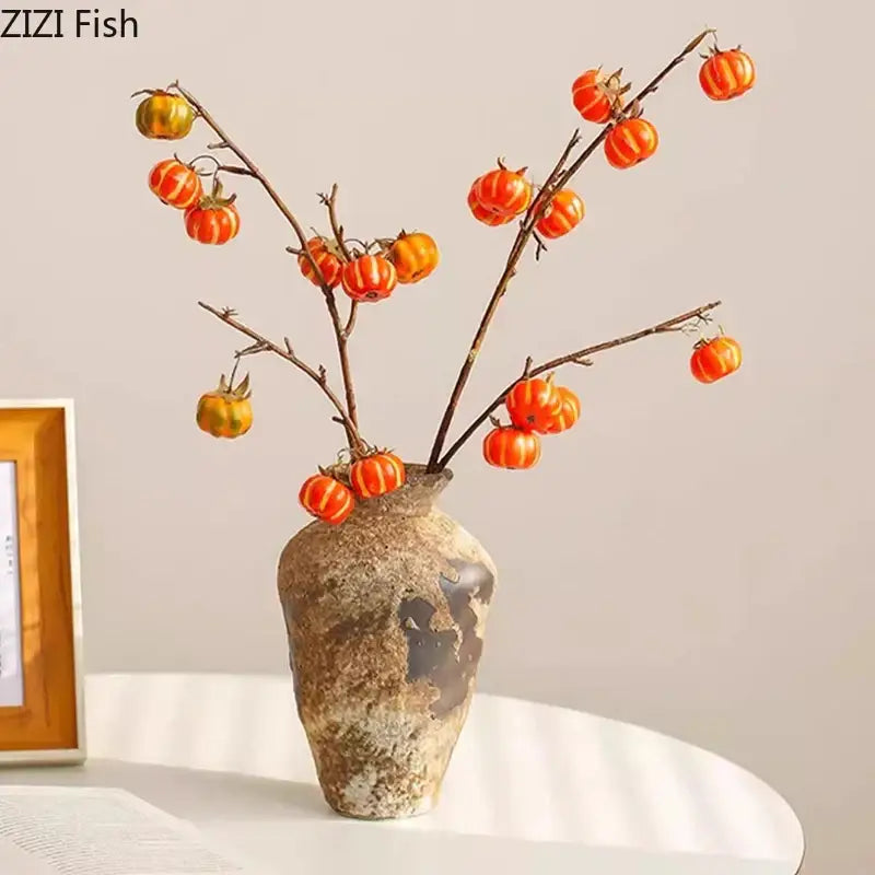 Wabi-sabi rustic brown decorbites ceramic vase with weathered finish holding branches with orange pumpkin decorbites ceramic vase