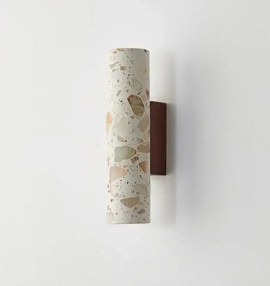 Wabi sabi terrazzo and wood led wall lights with cylindrical speckled white beige and brown stone sconce on dark wood backplate