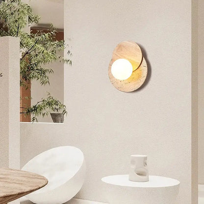 Modern wall lamp with warm circular light set in overlapping natural wood toned stone discs for cream style bedroom decorbites