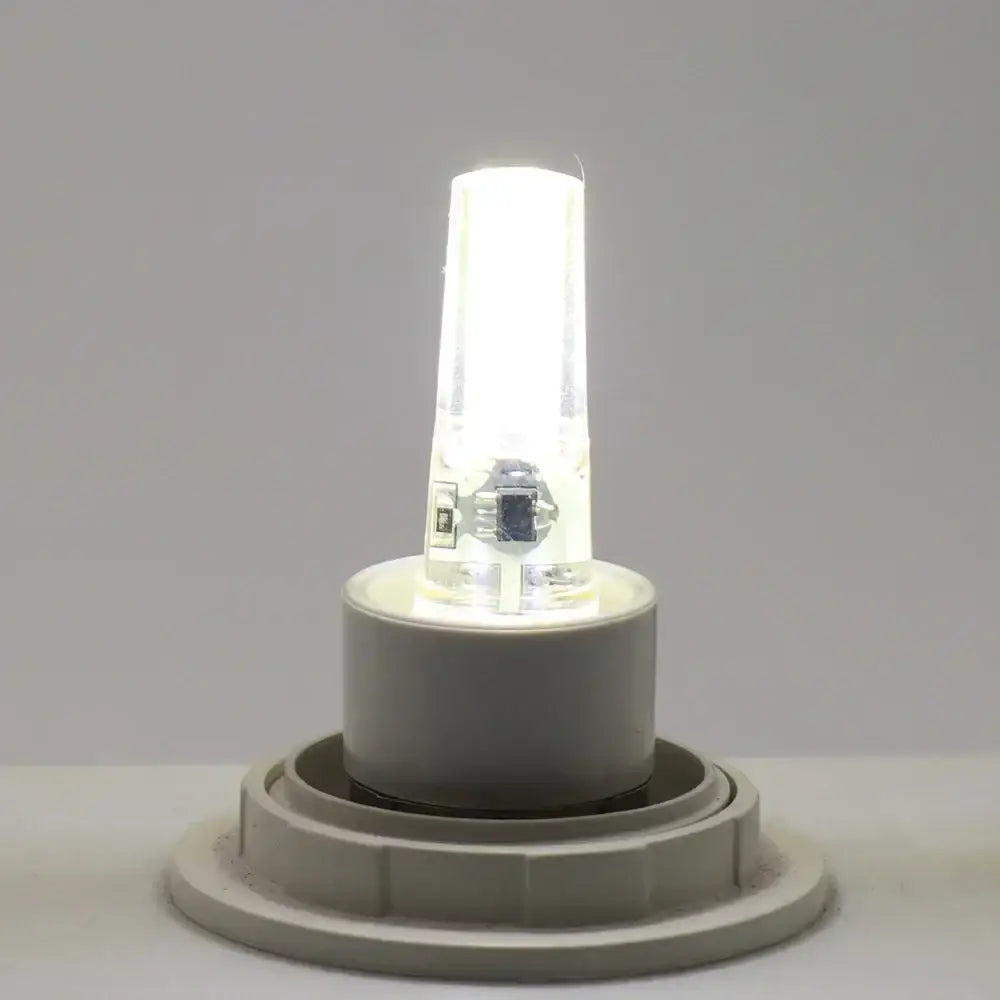 A sleek warm yellow glass decorbites g4 cob led bulb with clear glass housing and white plastic base for living room light