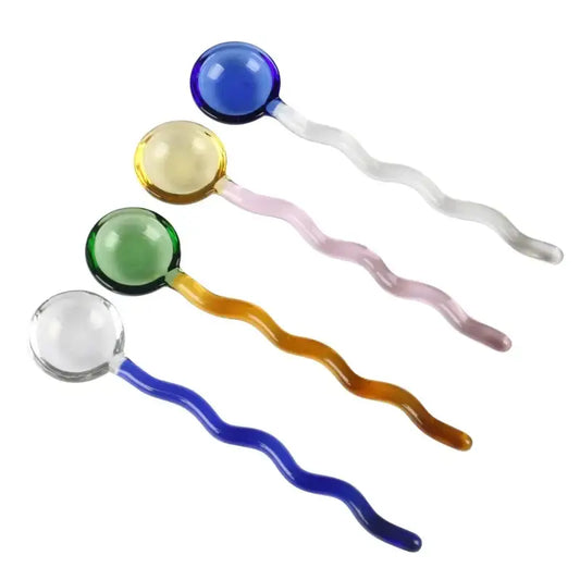 Four colorful glass spoon coffee stirring rods with wavy translucent handles in blue yellow green and clear