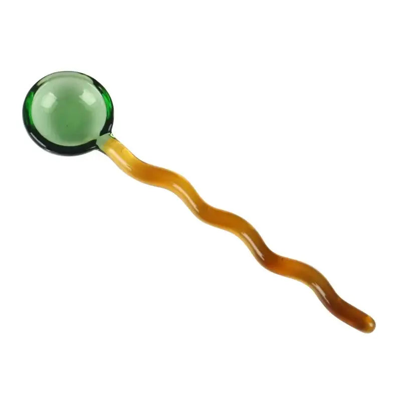 Translucent green glass sphere on wavy amber handle glass spoon coffee stirring rod for kitchen use