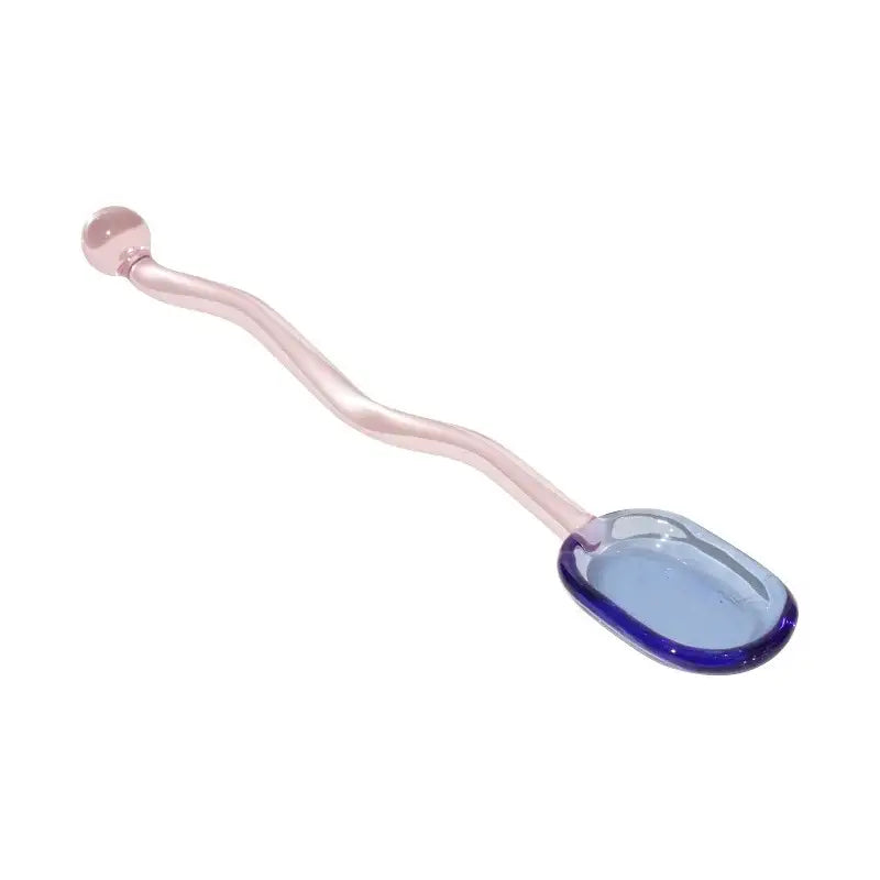 A translucent pink glass spoon coffee stirring rod with a wavy handle and blue-tinted oval bowl for kitchen use