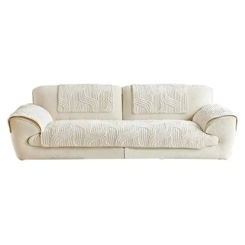Cream-colored quilted sofa cover with soft textured fabric and flowing wave pattern for living room use