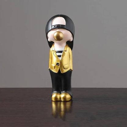 A glossy black and gold resin decorbites boys sports statue of a stylized person with a backward cap and golden shoes