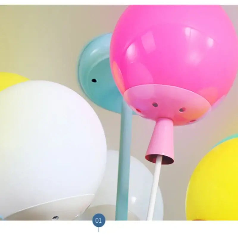 A vibrant pink balloon ceiling chandelier lamp with glossy finish and matching conical wooden base for nursery