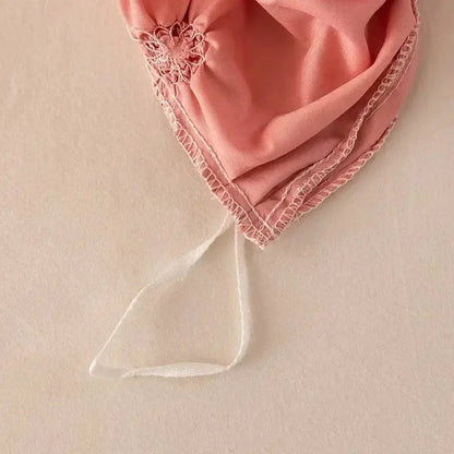 A delicate pink satin bonnet with lace trim and white ribbon tie paired with a white 3d pinch pleat duvet cover set