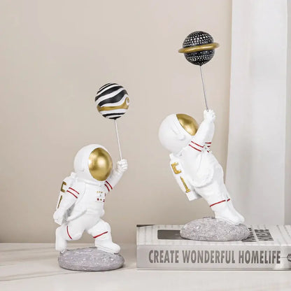 White and gold decorbites astronauts figurines with red detailing holding patterned planet balloons for living room decor