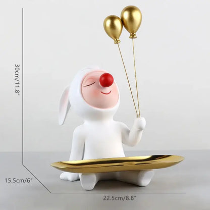 White and gold ceramic clown bust sculpture featuring a white bunny with a red nose holding gold balloons on a tray