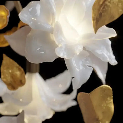 White and gold crystal flower luxury chandelier featuring a translucent white ceramic flower with golden leaf accents
