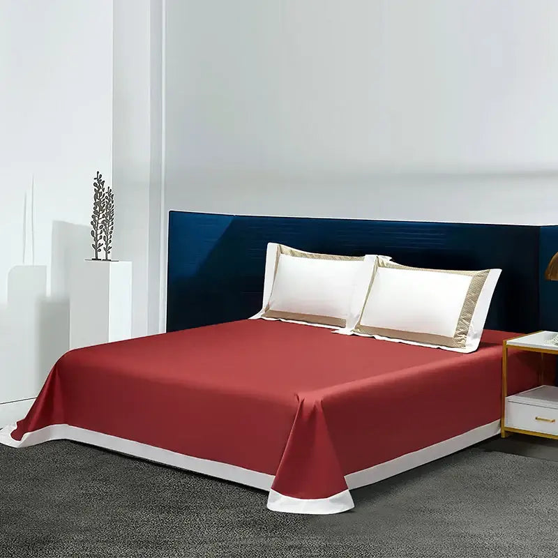 Red bedsheet with white trim as part of white and gold egyptian cotton bedding set with gold embroidery for bedroom