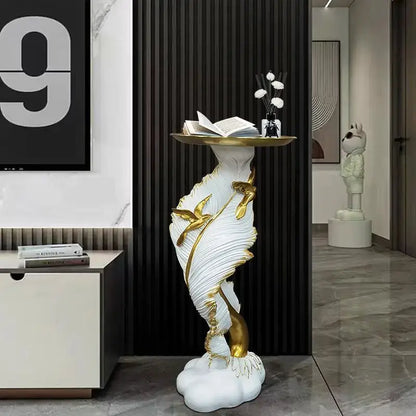 White and gold sculptural console table with feather floor decoration design holding an open book and vase