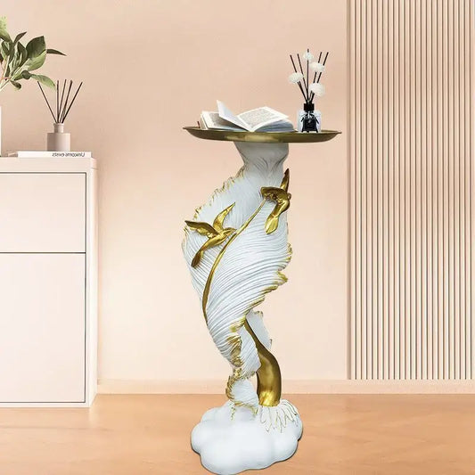 White and gold feather floor decoration side table with golden hummingbirds and an open book on its circular top