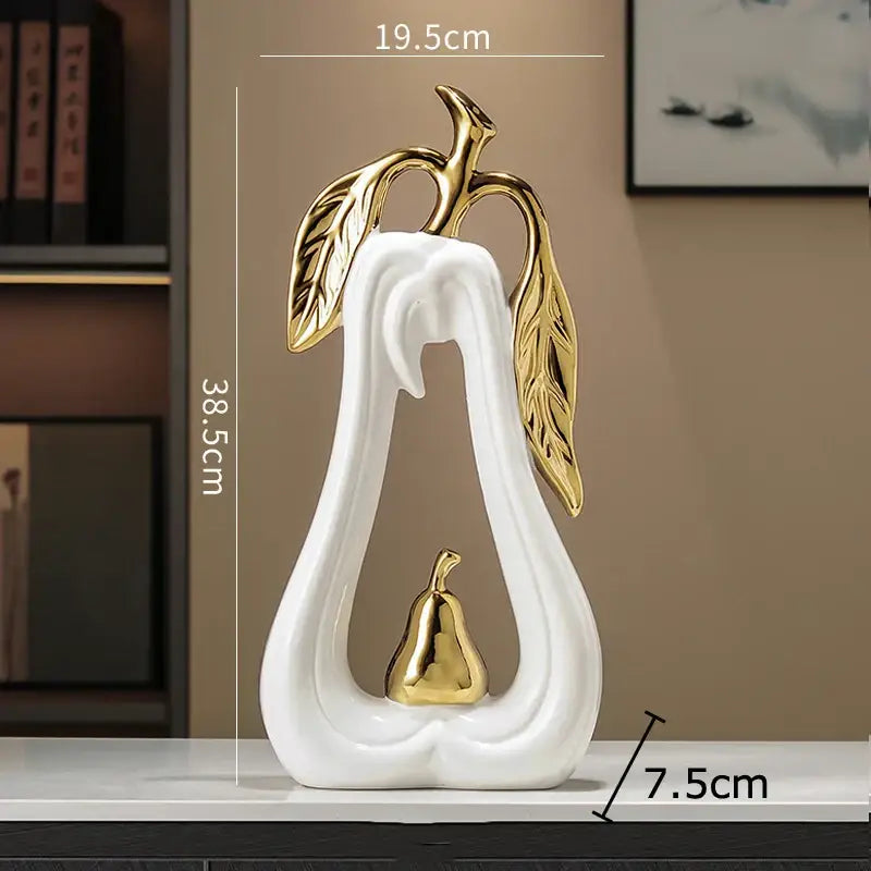 White and gold pear ceramic desk ornament featuring a white ceramic pear with gold leaf and a smaller gold pear inside decorbites gold pear