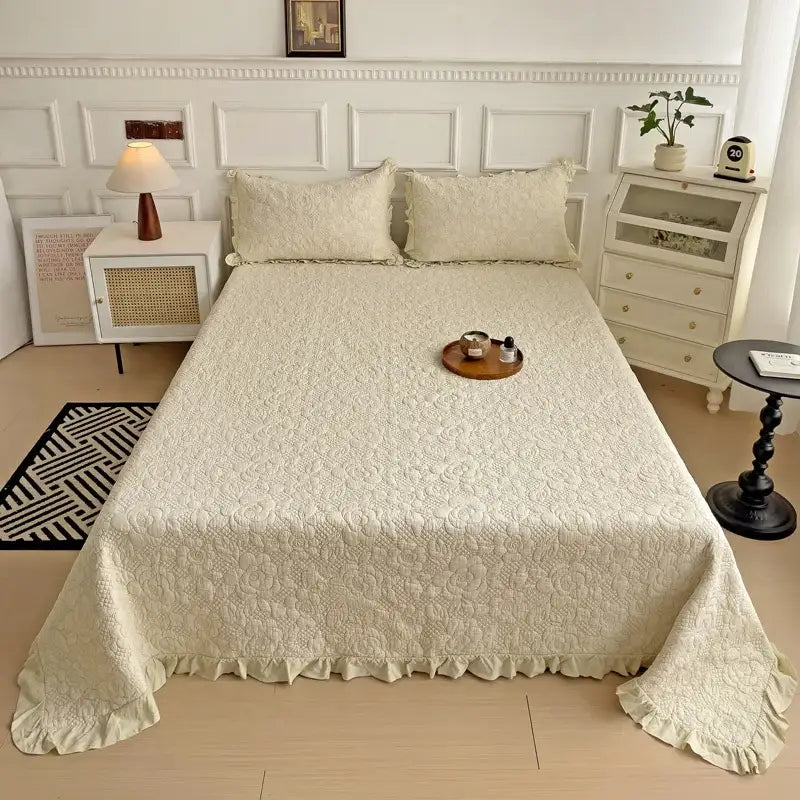 Cream-colored cotton quilted embroidered bedspread set with delicate floral embroidery and soft ruffled hem by decorbites