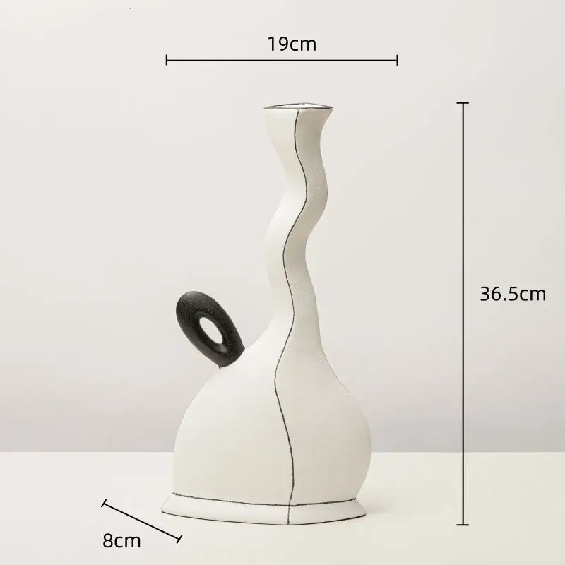A sleek white ceramic vase with a wavy form and black circular handle featuring geometric black lines for living room decor