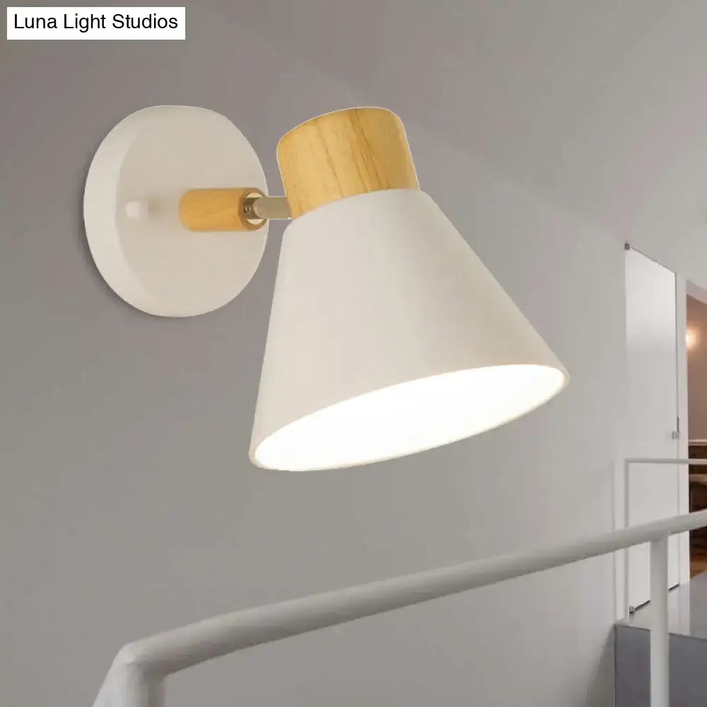 Modern wall mount light with a white conical shade, wood-finished top, and circular white mounting plate for bedrooms
