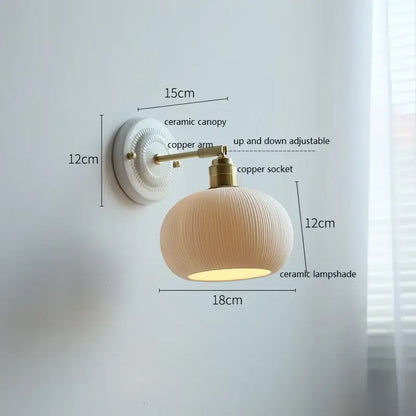 Cream-colored butterfly ceramic led wall lamp with ribbed scalloped shade and brass-finished copper arm for bedroom use