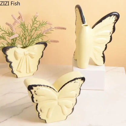 White butterfly ceramic vase by decorbites with cream color black-trimmed wings and central plant opening for decor