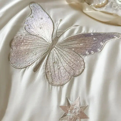 A white butterfly lace ruffles bedding set featuring a delicately embroidered silver butterfly appliqué with iridescent wings