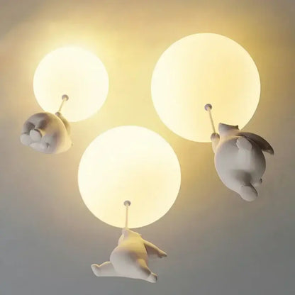 White ceramic bear pendant light featuring three whimsical off-white ceramic balloon bears hanging from spherical fixtures