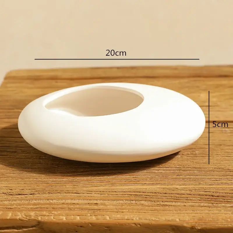 White cobblestone deformation ceramic ashtray with smooth oval shape and central opening for decorbites cobblestone deformation decor