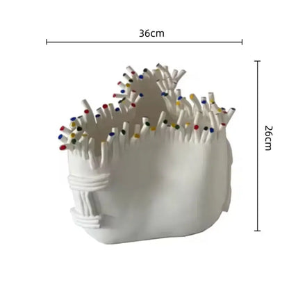 White ceramic flower pot vase with coral shapes textured surface holding colorful tipped matches for living room decor