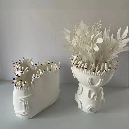 White ceramic flower pot vase with coral shapes filled with colorful pencil tips for living room decor