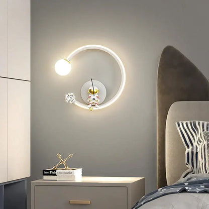 Modern circular white crescent astronaut wall lamp with glowing ring and gold-toned figurine for bedroom decorbites astronaut wall