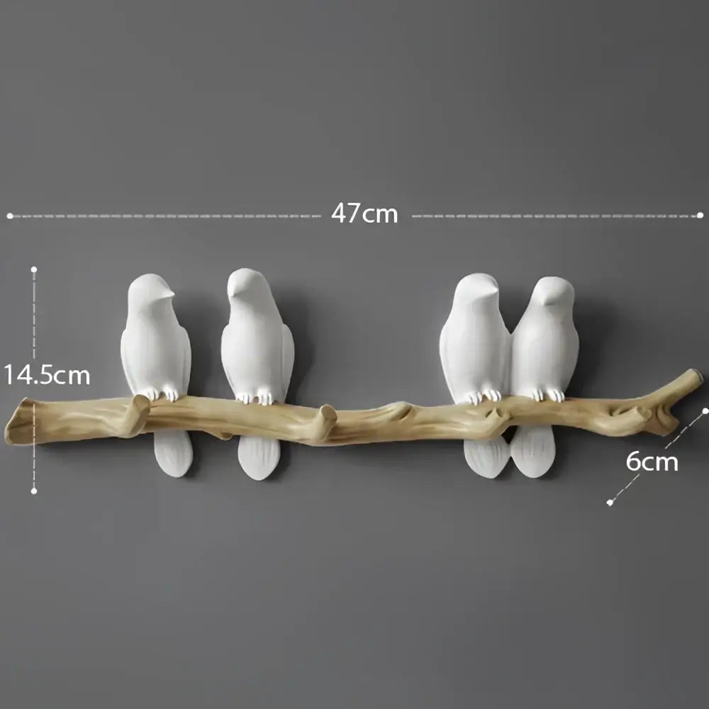 White decorbites bird resin hanger with two white ceramic birds perched on a rustic wooden branch wall decor