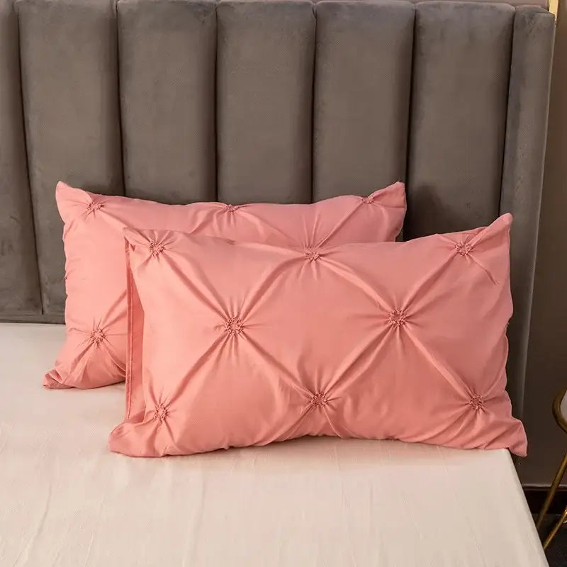 Pink satin pillowcases with diamond-shaped tufting and buttons in white diamond pinch pleated duvet cover set