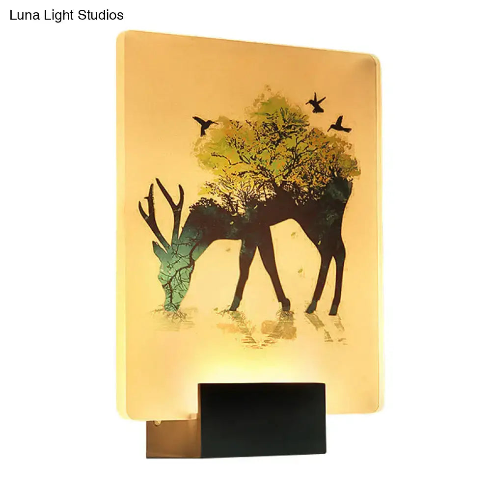 Warm-toned white elk tree led wall sconce with deer silhouette and tree branches illuminated by soft yellow light