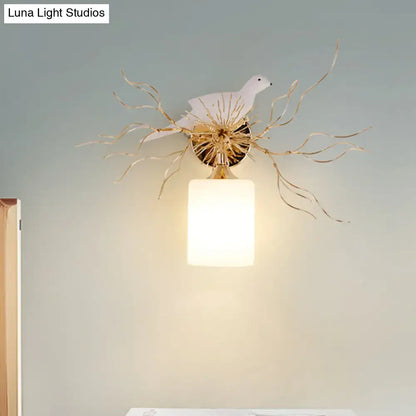 White glass bird wall lamp with led features a white ceramic dove on a gold branch with an illuminated frosted shade for bedroom