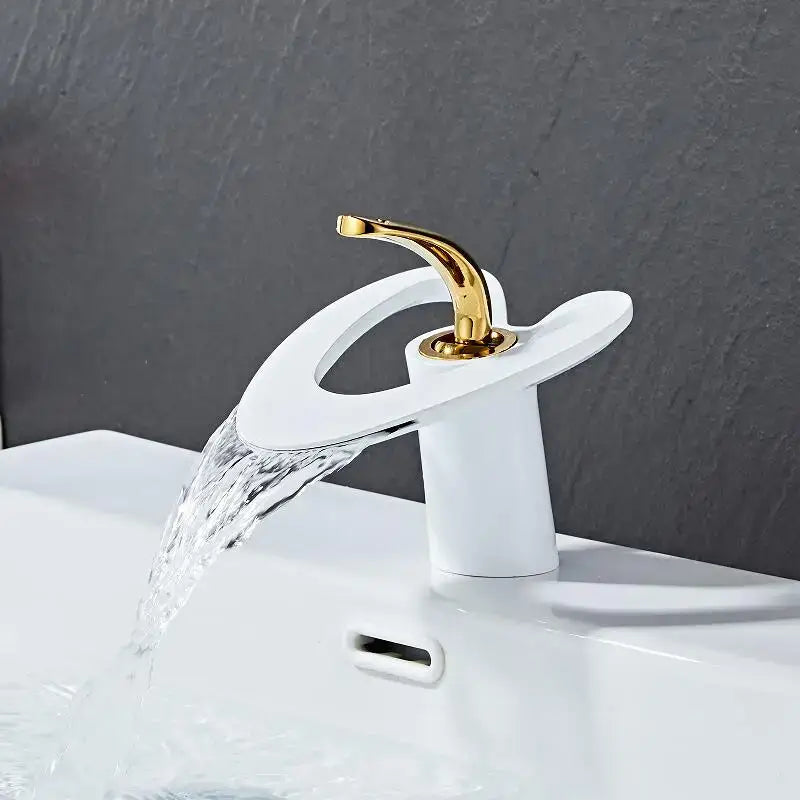 A modern white ceramic basin faucet with a sleek curved spout and gold-toned handle for decorbites golden white style