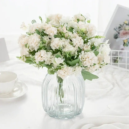 White hydrangea bouquet with green foliage in a clear ribbed glass vase for living room decor by decorbites hydrangea bouquet