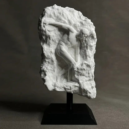White marble discus throwing nude sculpture in dynamic pose carved into rugged rock for home decor in living room