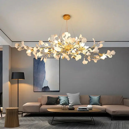A modern gold-toned decorbites ginkgo chandelier with white leaf accents pendant light for living room use