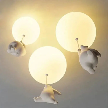 Three white ceramic polar bear pendant lights holding glowing bulbs as cord pendant fixtures for kids bedroom
