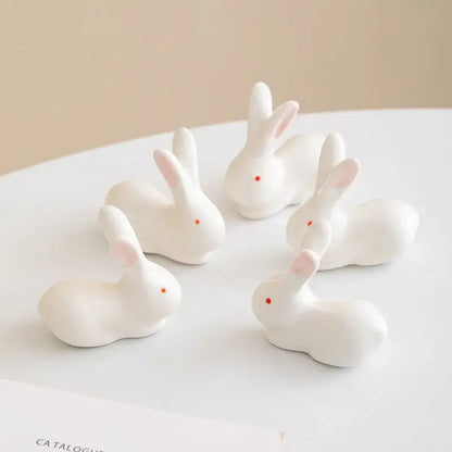 White porcelain duck chopstick holder tray featuring white ceramic bunny figurines with pink ears and red dot eyes